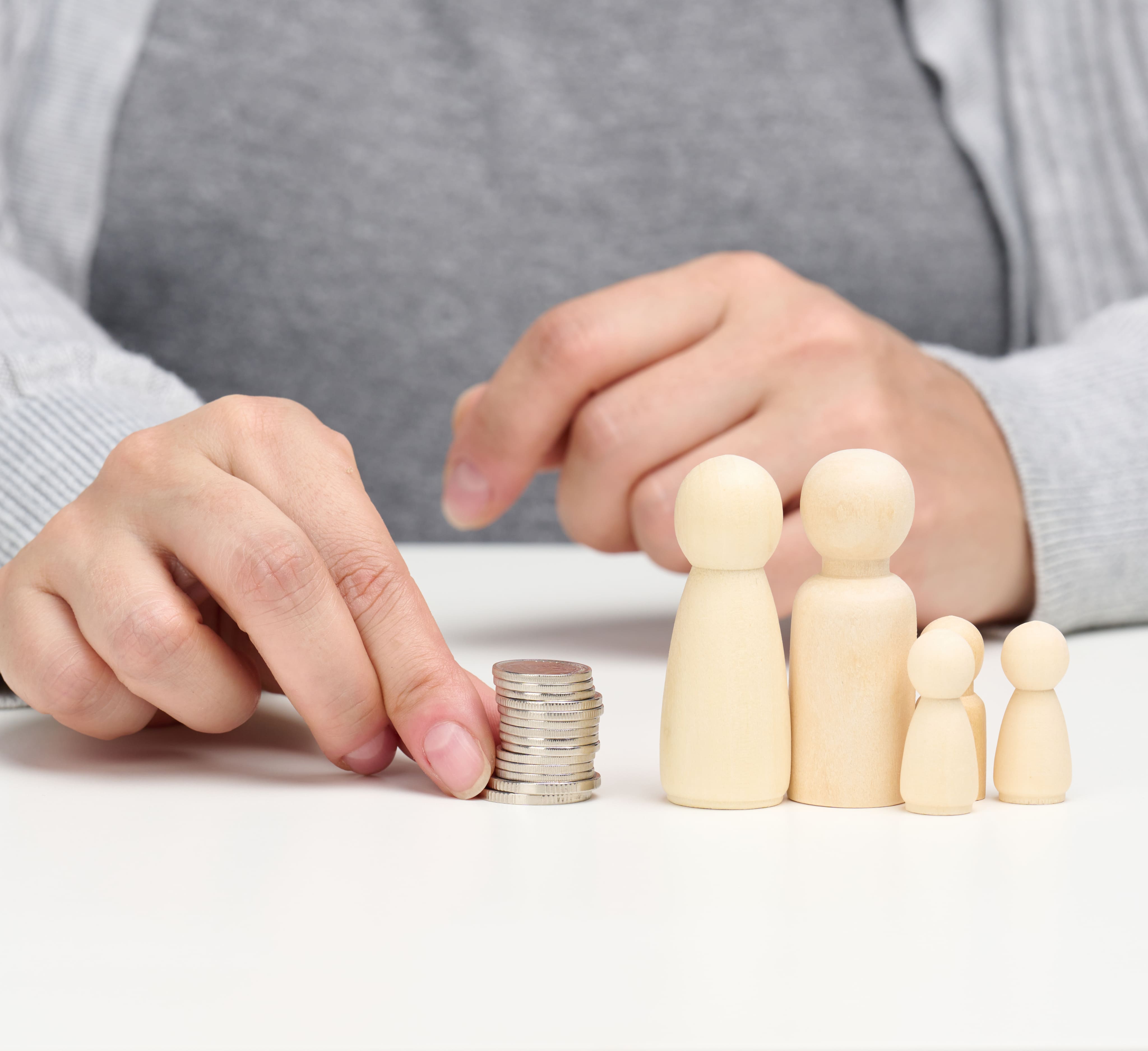 Pièces et figurines en bois illustrant le financement familial